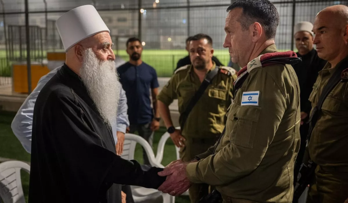 لطالما مثّل الدروز في فلسطين قصةً شديدةَ التعقيد، تحولوا خلالها إلى مكون أساسي في الجيش الإسرائيلي بعدما كانوا جزءًا أصيلًا من فلسطين، وخاضوا رحلة شديدة المرارة اختلطت فيها أسئلة الهوية بمحاولات الاندماج. في مطلع القرن الحادي عشر الميلادي، عام 1017، وفي فترة حكم الدولة الفاطمية بمصر، نشأت طائفة الدروز الدينية، الذين أطلقوا على أنفسهم لقب "الموحدون". انتشر الدروز بشكل أساسي في المناطق الجبلية ببلاد الشام؛ جبل حوران، ويعرف أيضًا باسم جبل الدروز في السويداء، جنوب شرق سوريا، وجبل الشوف وعاليه وحاصبيا في لبنان، والجليل والكرمل في فلسطين. لعب الدروز أدوارًا في مقاومة الدولة العثمانية ومحاولات فرض سيطرتها الإدارية والجبائية الكاملة على مناطقهم الجبلية. وفي مرحلة لاحقة تصدروا المشهد المقاوم للاحتلال الفرنسي لسوريا، عندما أطلق سلطان باشا الأطرش عام 1925 شرارةَ الثورة السورية الكبرى ببيان سياسي عسكري يدعو فيه إلى حمل السلاح. واليوم، هناك نحو 150 ألف درزي يحملون الجنسية الإسرائيلية في الجليل والكرمل، ونحو 20 ألفًا في الجولان السوري المحتل الذي أعلنت إسرائيل ضمّه إليها عام 1981 ما زالوا متمسكين بهويتهم السورية ويرفضون الحصول على الجنسية الإسرائيلية. العصا والجزرة قبل إعلان دولة إسرائيل عام 1948، لا توجد أي دلائل تشير إلى أن الدروز كانوا طائفةً منفصلةً عن بقية سكان فلسطين. على العكس، كانت القرى الدرزية في مناطق الجليل والكرمل تندمج بشكل طبيعي في الحياة الريفية الفلسطينية. شارك السكان في الزراعة والتجارة، وتفاعلوا يوميًا مع جيرانهم من مختلف الخلفيات. وكان الدروز في فلسطين جزءًا من الحراك السياسي الذي واجه الانتداب البريطاني والتوسع الصهيوني في ذلك الوقت. رغم الضغوط الإسرائيلية شهدت القرى الدرزية حالات فردية وجماعية لرفض الخدمة العسكرية ولكن في مايو/أيار 1948 بدأت مرحلةٌ جديدةٌ مع اضطرار الدروز للتفاعل مع الكيان الجديد، الذي أدركت قياداته أهمية الدروز كطائفة منظمة يمكن استغلالها، وبدأت تطبيق سياسات تهدف إلى فصلهم عن بقية السكان الفلسطينيين، ضمن استراتيجية تعتمد على التمييز. ففي عام 1956، فُرض التجنيد الإجباري على الشباب الدرزي في الجيش الإسرائيلي. لم يطبق الإجراء نفسه على غيرهم من فلسطينيي الـ48 من مسلمين ومسيحيين. وقد وضَع هذا القرار الدروز في موقف حرج وأحدث انقسامًا داخل المجتمع الدرزي، بين من استجابوا للقرار ومن حاولوا مقاومته. لكن في العام التالي، اعترفت إسرائيل بالطائفة الدرزية "جماعة قومية" منفصلة، ومنحتها محاكم دينية خاصة. هذا الامتياز أيضًا لم يُمنح لبقية الفلسطينيين، ومثَّل خطوة هدفت إلى عزل الدروز وإيهامهم بوضع خاص. رغم الضغوط الإسرائيلية، شهدت القرى الدرزية حالات فردية وجماعية لرفض الخدمة العسكرية. تعرض هؤلاء الرافضون للسجن والحرمان من بعض الحقوق المدنية والوظيفية، لكنهم تمسكوا بموقفهم. وبعد أن أعلنت إسرائيل ضمَّ الجولان السوري المحتل وفرضت قوانينها على أهاليه الدروز في عام 1981، اندلعت احتجاجات شعبية واسعة رفضًا للضم ولفرض الجنسية الإسرائيلية على السوريين من أهله وأعلنوا الإضراب والعصيان المدني. استمرت هذه الاحتجاجات أشهرًا، وواجه الدروز غير المسلحين إجراءات قمعية إسرائيلية، لكنهم أصروا على التمسك بهويتهم السورية، رافضين محاولات التهويد. بالتزامن مع القمع، استخدمت إسرائيل أيضًا استراتيجية الترغيب، فمنحت امتيازات مالية مقابل الخدمة العسكرية، وضمنت لهم فرص عمل في القطاع العام والأجهزة الأمنية والبلديات الدرزية. وفّرت هذه الوظائف استقرارًا اقتصاديًا وترقيًا اجتماعيًّا لم يكونا متاحين لبقية فلسطينيي الـ48. كما خُصصت ميزانيات أكبر لتطوير البنية التحتية والخدمات في القرى الدرزية ما أرسل رسالةً بأن "الولاء يحمل مكافآت". تزامن هذا مع تعديل المناهج التعليمية في المدارس الدرزية لترسيخ "هوية درزية إسرائيلية" وتهميش الارتباط بالجذور الفلسطينية. ساهمت هذه السياسات في خلق انقسام داخل المجتمع الدرزي نفسه، بين فئة رأت مصلحتها في الاندماج وخدمة الدولة، وفئة أخرى أصرت على الحفاظ على هويتها الأصلية ورفضت التجنيد. قانون القومية.. سؤال الهوية حتى وقتنا الحاضر، لا تزال علاقة الدروز بإسرائيل تتسم بالتعقيد. فعلى الرغم من عقود من الخدمة العسكرية، فإنه عند مفترق الطرق في 2018، تكشَّف للدروز بوضوح أنهم مواطنون من الدرجة الثانية، وذلك بعد أن أقر الكنيست قانون القومية الذي ينص على أن إسرائيل هي "الدولة القومية للشعب اليهودي". هذا القانون أظهر بوضوحٍ أن الدروز، رغم تضحياتهم وخدمتهم في الجيش، لا يزالون يُعتبرون مواطنين من درجة أقل في دولة تُعرف نفسها بشكل عرقي وديني. أثار قانون القومية استياءً واسعًا داخل المجتمع الدرزي، بما في ذلك بين ضباط وجنود سابقين في الجيش الإسرائيلي. نُظمت مظاهرات احتجاجية مطالبة بالمساواة الكاملة والاعتراف بهم مواطنين متساوين، إذ أدركوا أن خدمتهم العسكرية لم تضمن لهم المساواة الموعودة. وعاد النقاش حول التجنيد الإجباري يتصاعد بين الشباب الدرزي، وبدأ البعض يتساءل عن جدوى الخدمة في جيش دولة لا تعترف بهم ضمن إطارها القومي.